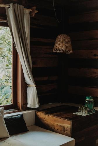 a room with a window with a table and a lamp at BOA BOA Bacalar in Bacalar