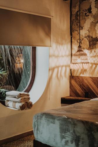 a bedroom with a bed and a window at BOA BOA Bacalar in Bacalar