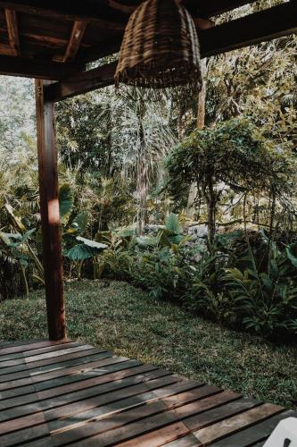 a wooden walkway in a garden with trees and plants at BOA BOA Bacalar in Bacalar