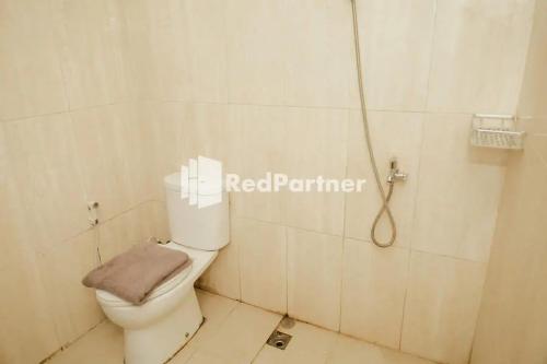 Pipulu的住宿－Radja Homestay Mitra RedDoorz，浴室配有白色卫生间和淋浴。