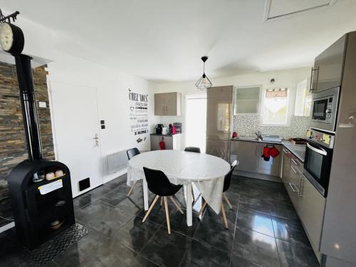- une cuisine et une salle à manger avec une table et une cuisinière dans l'établissement Maison 3 chambres, jardin clos, plage à proximité, bien équipé, WiFi, parking - FR-1-197-535, à Les Sables-dʼOlonne