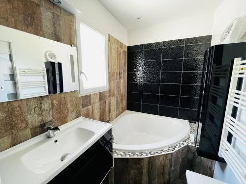 une salle de bain avec une baignoire blanche et un lavabo dans l'établissement Maison 3 chambres, jardin clos, plage à proximité, bien équipé, WiFi, parking - FR-1-197-535, à Les Sables-dʼOlonne