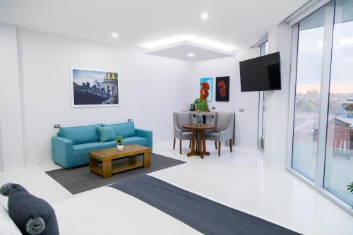 a living room with a blue couch and a table at Hotel GRALTA in Jalostotitlán