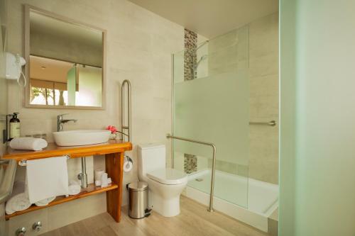 a bathroom with a toilet and a sink and a shower at Hotel Ohana Rapa Nui in Hanga Roa