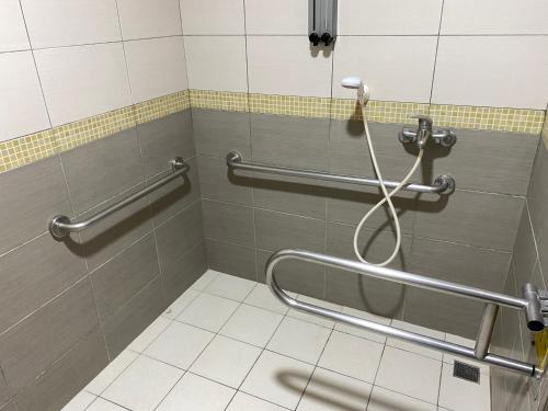 łazienka z prysznicem z dwoma poręczami w obiekcie Zhongshan Boutique Hotel w mieście Kaohsiung