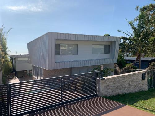 a house with a fence in front of it at Sea and Salt Hyams Beach in Hyams Beach