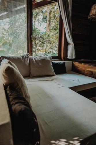 a couch in a room with a large window at BOA BOA Bacalar in Bacalar