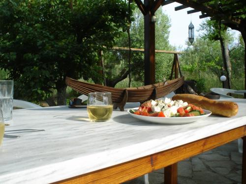 una mesa con un plato de comida y una copa de vino en Bozelia Apartments, en Toroni