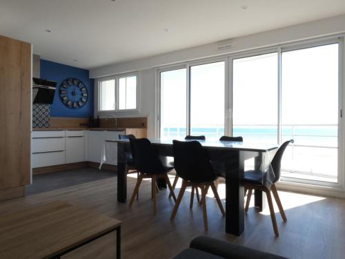 une salle à manger avec une table, des chaises et une horloge dans l'établissement Appartement moderne 2 chambres, vue mer, WiFi, Saint-Jean-de-Monts - FR-1-323-230, à Saint-Jean-de-Monts