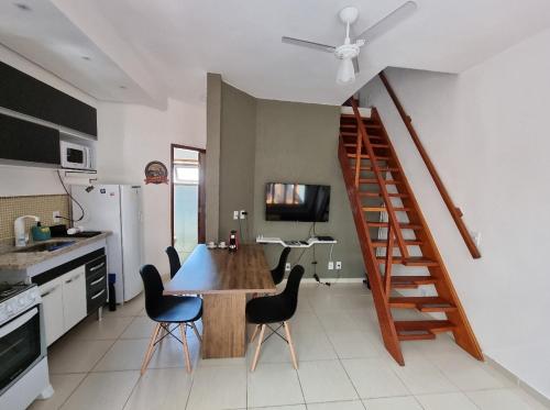 una cocina con mesa y sillas y una escalera en Afras Maresias en São Paulo