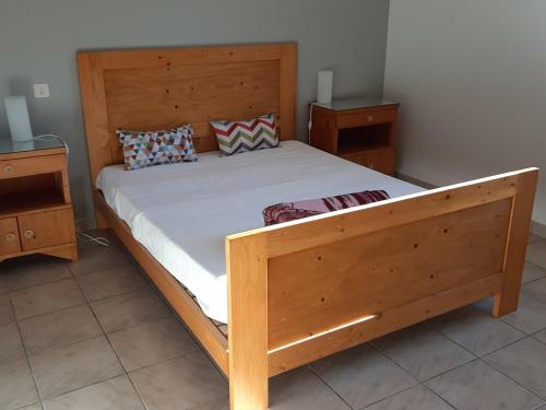 uma cama de madeira num quarto com duas mesas de cabeceira em Maison Seignosse, 5 pièces, 8 personnes - FR-1-239-600 em Seignosse