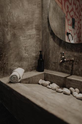 a bathroom with a bath tub with towels and a sink at BOA BOA Bacalar in Bacalar