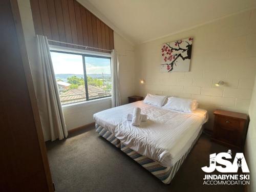 a hotel room with a bed and a window at Moonbah 2 in Jindabyne