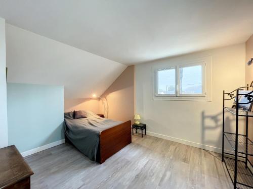 an attic bedroom with a bed and a window at Villa proche Plage et Centre, Jardin Clos, Wifi, Chien possible - FR-1-361-431 in Jullouville-les-Pins