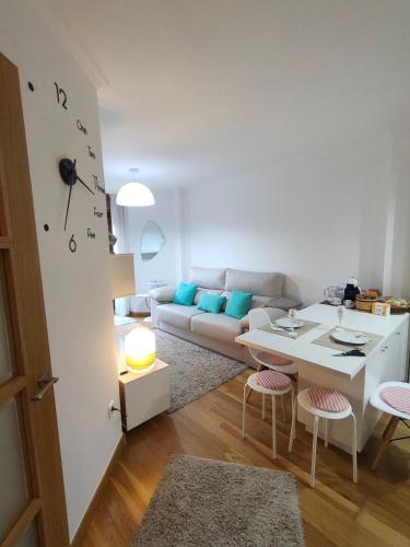 - un salon avec un canapé blanc et une table dans l'établissement Apartamento Pontevedra centro HOMYHOME II, à Pontevedra