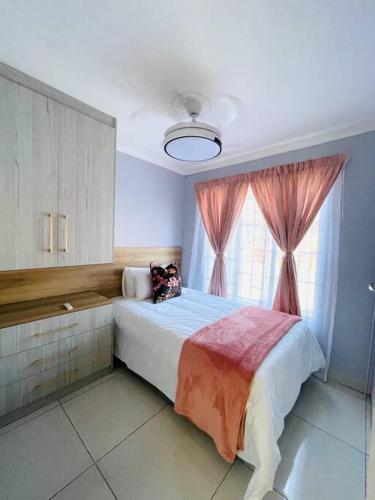 um quarto com uma cama grande e uma janela em Are you travelling to Pretoria? em Pretoria