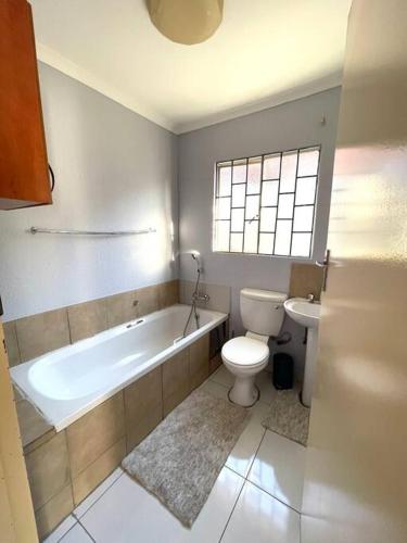La salle de bains est pourvue d'une baignoire, de toilettes et d'un lavabo. dans l'établissement Are you travelling to Pretoria?, à Pretoria
