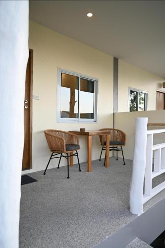 a room with a table and chairs and a window at Bao Village in Haad Yao