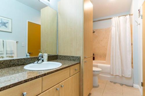 a bathroom with a sink and a toilet at A Corner Unit with OCEAN VIEWS from EVERY ROOM in Long Beach