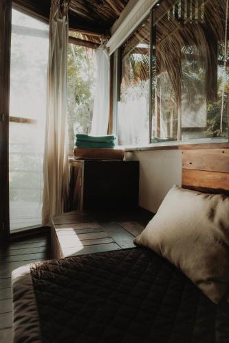 a bedroom with a bed in front of a window at BOA BOA Bacalar in Bacalar