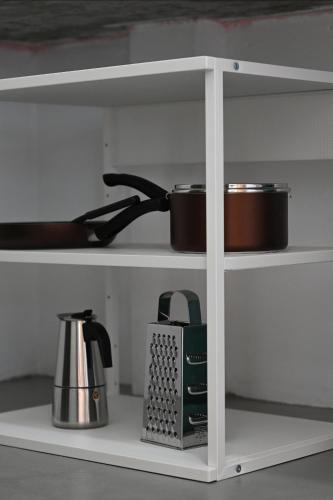 a white shelf with pots and pans on it at Bao Village in Haad Yao