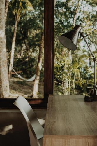 a desk with a lamp and a chair next to a window at BOA BOA Bacalar in Bacalar