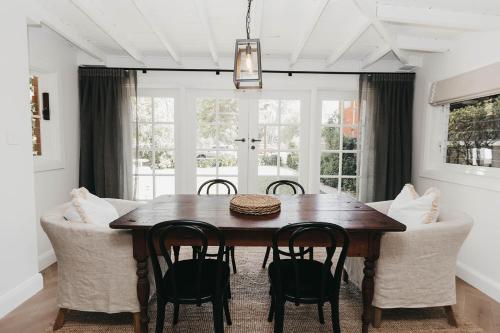 a dining room with a wooden table and chairs at Mopsy's On The Esplanade in Wagga Wagga
