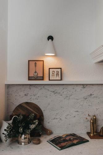 a shelf above a fireplace with two pictures on it at Mopsy's On The Esplanade in Wagga Wagga