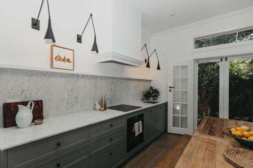 a kitchen with gray cabinets and a counter top at Mopsy's On The Esplanade in Wagga Wagga