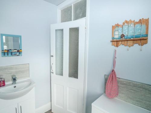 Łazienka z białymi drzwiami i umywalką w obiekcie Dunholme House w mieście Teignmouth