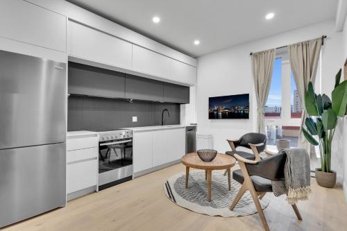 a kitchen with white cabinets and a table and chairs at Deluxe Suites Downtown Montreal in Montréal