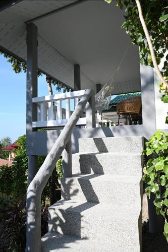 a stairway leading up to a building with its shadow at Bao Village in Haad Yao