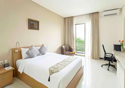 Cette chambre comprend un grand lit et une fenêtre. dans l'établissement Le Premier Hotel Deltamas, à Cikarang
