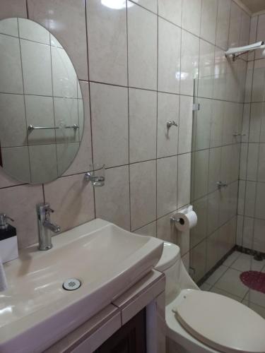 a bathroom with a toilet and a sink and a mirror at Casa para descanso en las montañas nicoyanas 