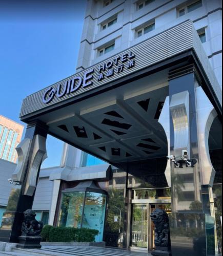 a sign for a hotel in front of a building at Guide Hotel Kaohsiung Liuhe in Kaohsiung
