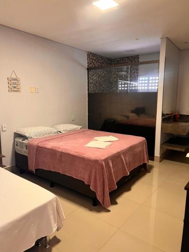 a bedroom with a bed with a red blanket at Suites Stival Centro in Goiânia