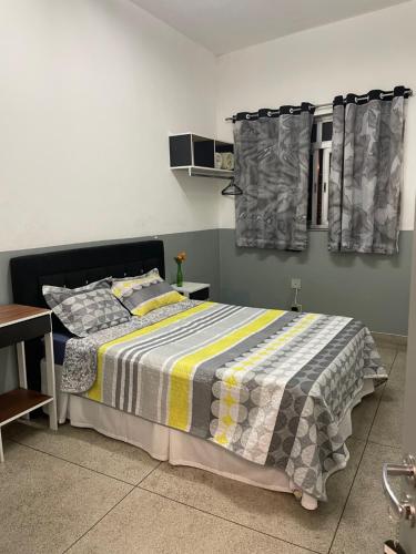 una camera con un letto con una coperta a righe di Hostel Lize a Cumbica