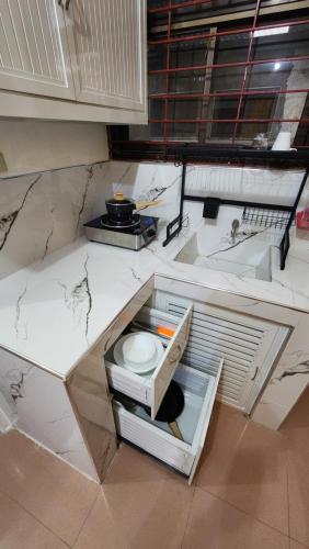 a kitchen with a white counter top with an open drawer at PARB Tuguegarao in Tuguegarao City