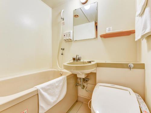 een kleine badkamer met toilet en wastafel bij Hotel Primrose Saito in Saito