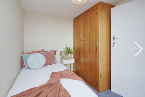 um quarto com uma cama e um armário de madeira em Stump Cottage em Christchurch