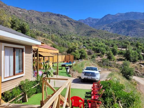 a car parked next to a house with mountains in the background at Casa San Francisco in Los Andes