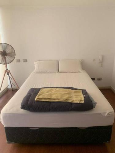 a bed with a blanket on it in a room at Departamento Tipo Estudio / 1 Ambiente in Santiago