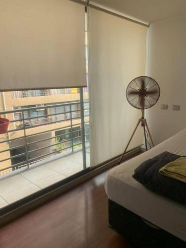 a bedroom with a large window and a fan at Departamento Tipo Estudio / 1 Ambiente in Santiago