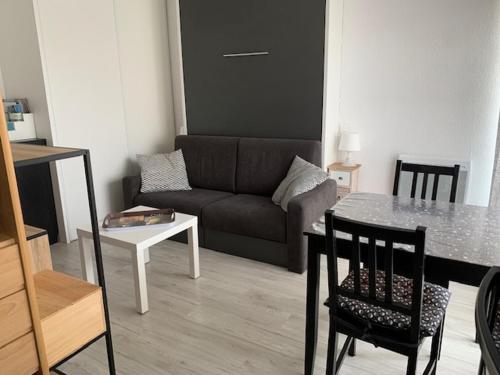 un salon avec un canapé et une table dans l'établissement Studio Climatisé ⭐⭐ à Proximité de l'Étang et des Thermes, avec Balcon et Wifi Gratuit - FR-1-503-145, à Balaruc-les-Bains