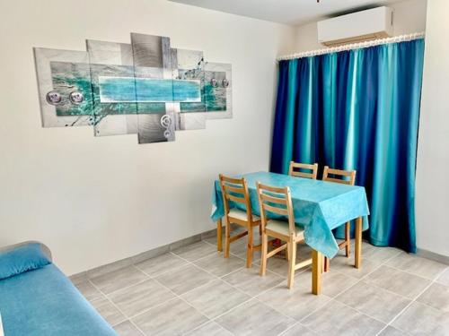 jadalnia z niebieskim stołem i krzesłami w obiekcie Studio climatisé avec garage et WiFi à 5 min des Thermes - FR-1-503-157 w mieście Balaruc-les-Bains