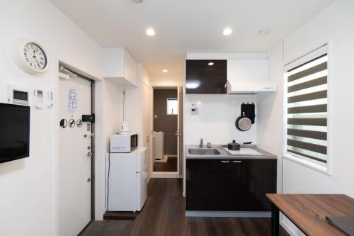 a kitchen with a white refrigerator and a sink at 5963 Hotel Higashi Ikebukuro in Tokyo