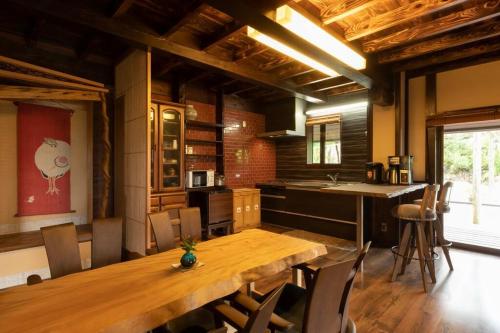 cocina grande con mesa de madera y sillas en 絶景を眼下に見渡す 天空のお宿 雅館, en Ichinoseki