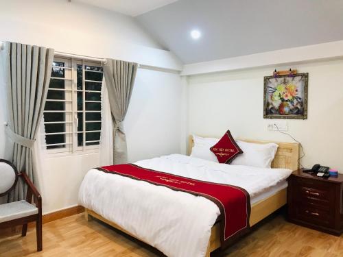 a bedroom with a large bed and a window at Khách sạn Hưng Việt (Măng Đen) in Kon Tum