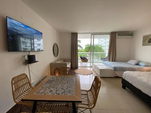 a living room with a bed and a table and chairs at Elegante y espacioso Apartamento en Playa Blanca in Río Hato