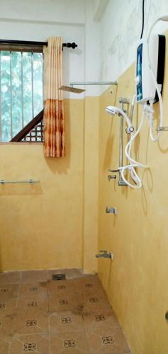 baño con ducha, TV y ventana en Twinkle Tangalle Villa en Tangalle